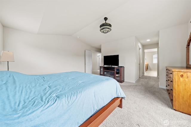 bedroom featuring baseboards, lofted ceiling, and light colored carpet