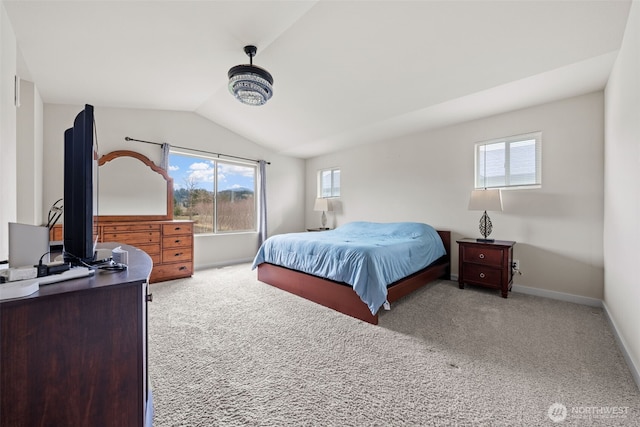 carpeted bedroom with baseboards and lofted ceiling