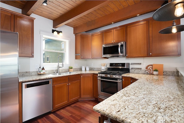 kitchen with brown cabinetry, dark wood-style floors, beam ceiling, a sink, and stainless steel appliances