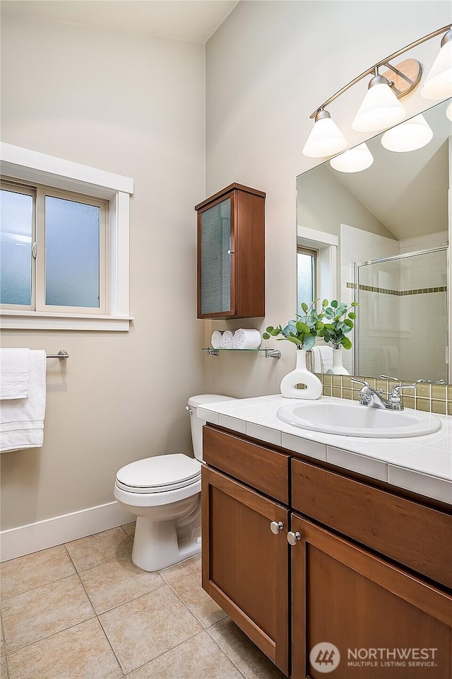 bathroom with vanity, tile patterned flooring, a shower stall, vaulted ceiling, and toilet