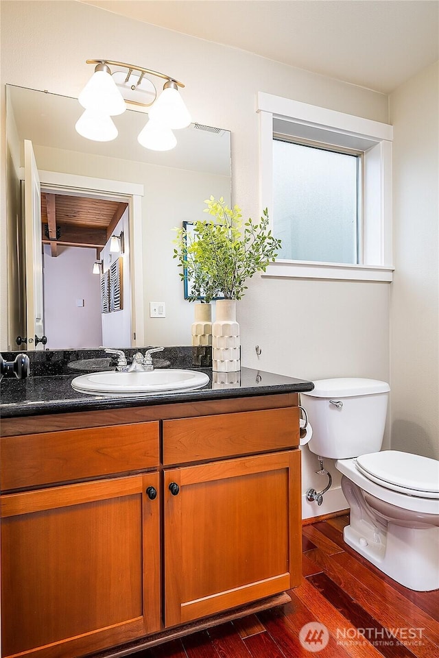 bathroom featuring vanity, toilet, and wood finished floors