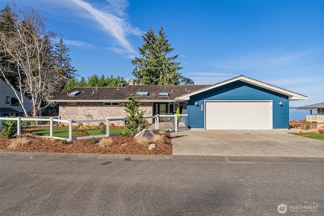 single story home featuring a fenced front yard, a garage, and concrete driveway