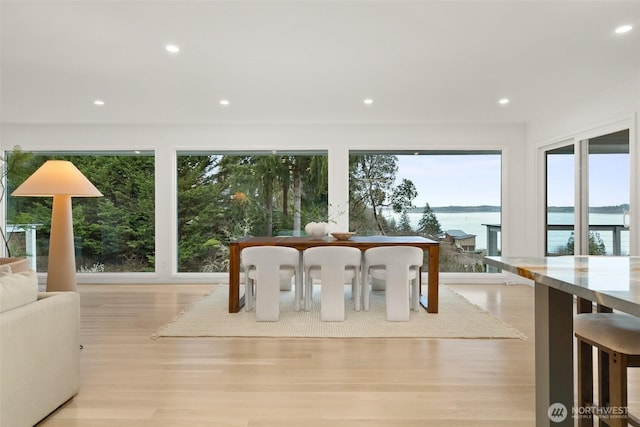 unfurnished dining area featuring recessed lighting, wood finished floors, and a water view