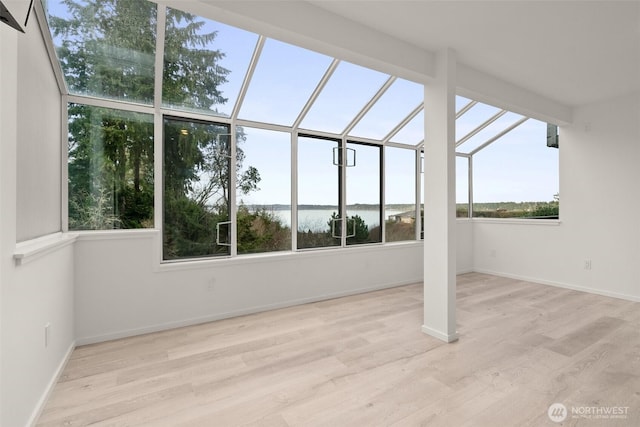 unfurnished sunroom with a water view