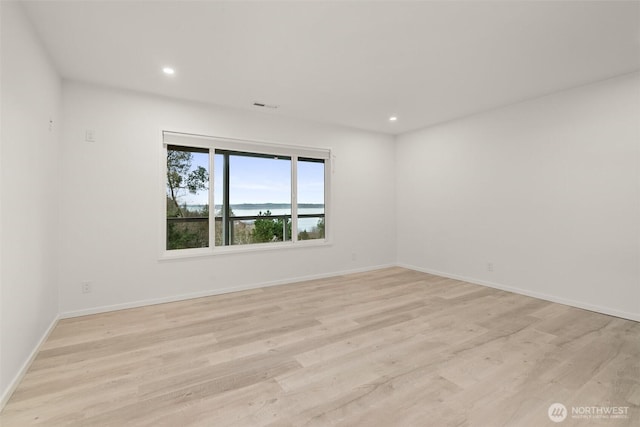 unfurnished room featuring recessed lighting, light wood-style flooring, and baseboards