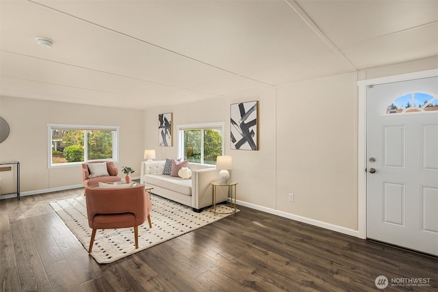 unfurnished living room with baseboards and dark wood-style flooring