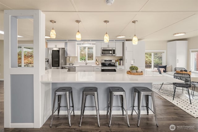 kitchen featuring a healthy amount of sunlight, appliances with stainless steel finishes, and a breakfast bar area