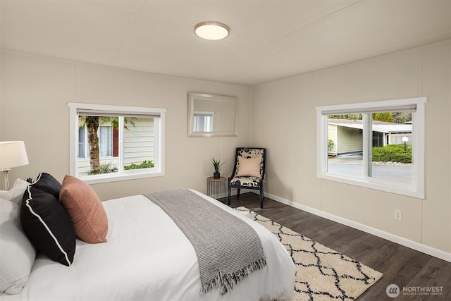 bedroom featuring baseboards and dark wood-style flooring