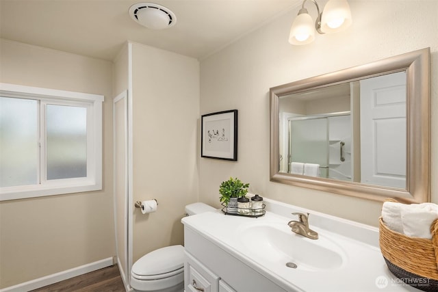 bathroom with vanity, visible vents, baseboards, a stall shower, and toilet