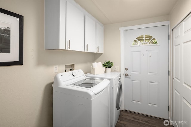 laundry room featuring dark wood finished floors, cabinet space, and washing machine and clothes dryer