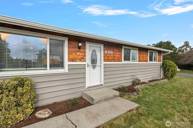 doorway to property featuring a yard