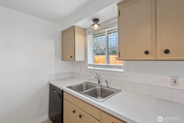 kitchen featuring baseboards, dishwasher, light countertops, cream cabinetry, and a sink