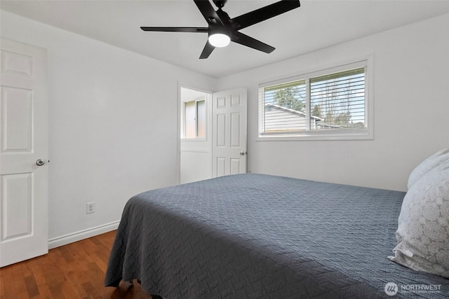 bedroom featuring baseboards, wood finished floors, and a ceiling fan