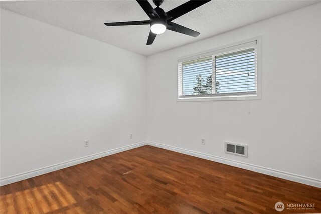 empty room with a ceiling fan, wood finished floors, visible vents, baseboards, and a textured ceiling