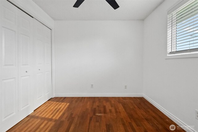 unfurnished bedroom featuring wood finished floors, baseboards, ceiling fan, a closet, and a textured ceiling