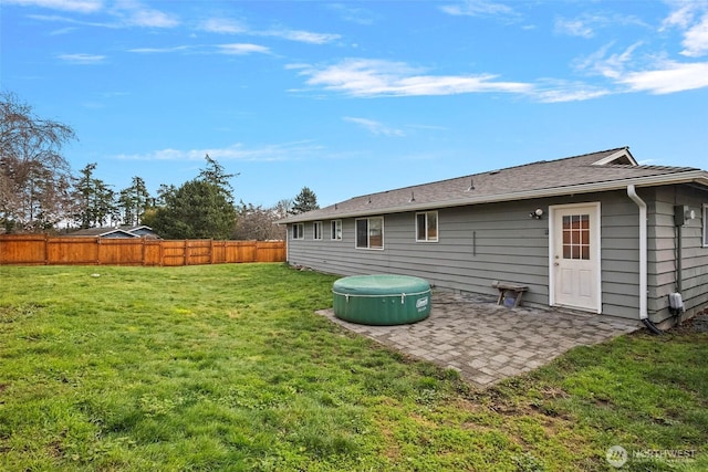 rear view of property with fence, a patio area, and a lawn