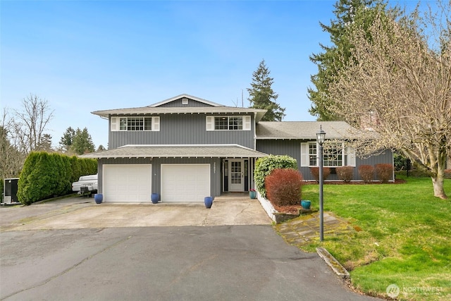 split level home with a front lawn, an attached garage, and driveway