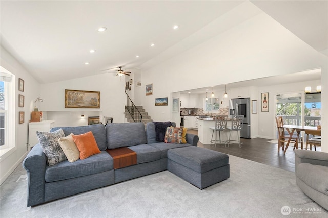 living room featuring baseboards, stairway, recessed lighting, high vaulted ceiling, and dark wood-style flooring