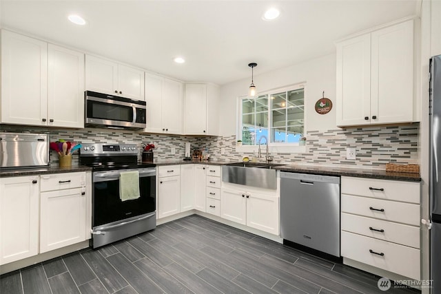 kitchen featuring a sink, backsplash, white cabinetry, recessed lighting, and appliances with stainless steel finishes