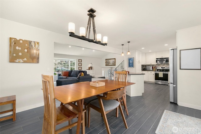 dining area with stairway, baseboards, a chandelier, and wood tiled floor