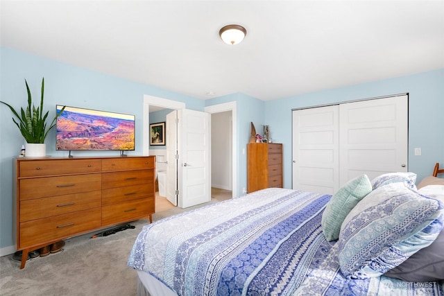 bedroom with light colored carpet, a closet, and baseboards