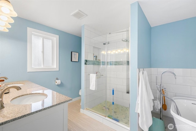 full bath with visible vents, toilet, a shower stall, a soaking tub, and vanity