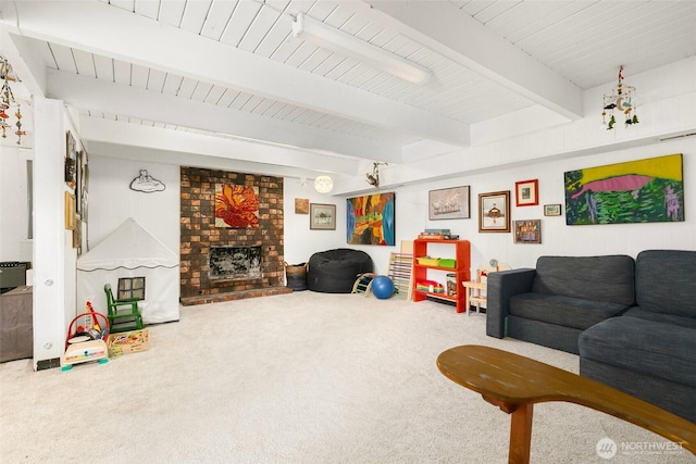 carpeted living area featuring visible vents, beam ceiling, and a brick fireplace