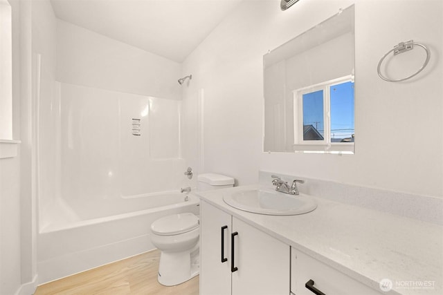 bathroom with washtub / shower combination, toilet, vanity, and wood finished floors