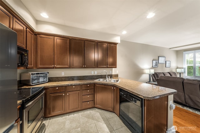 kitchen featuring a peninsula, a toaster, a sink, black appliances, and open floor plan