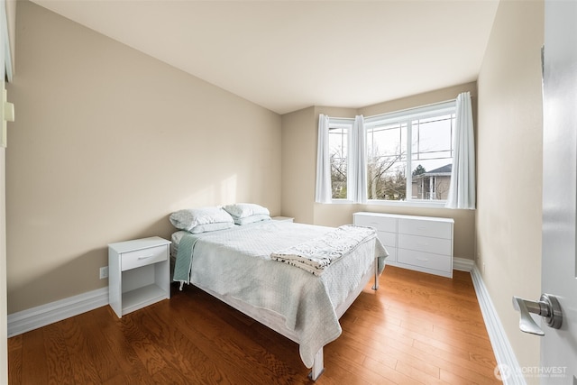 bedroom featuring baseboards and wood finished floors