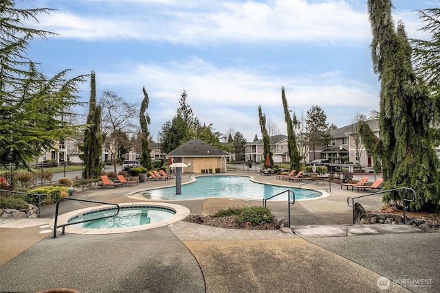 pool featuring a residential view, fence, a hot tub, and a patio area