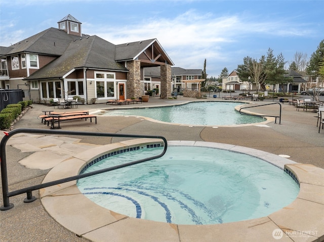 community pool featuring a patio area, a community hot tub, and fence