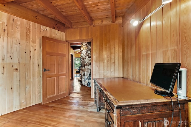 unfurnished office featuring beam ceiling, light wood-style floors, wood walls, and wooden ceiling