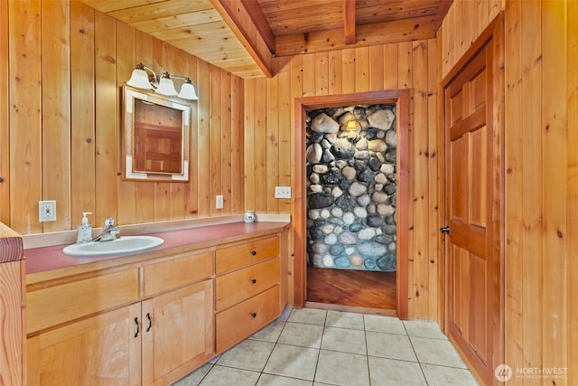 bathroom with tile patterned floors, wooden walls, wooden ceiling, and beam ceiling