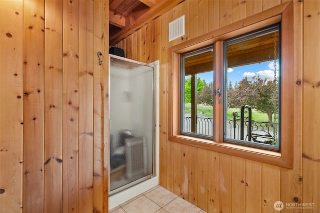 full bath featuring tile patterned flooring, visible vents, wood walls, and a shower stall