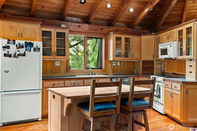 kitchen with light wood-style flooring, white appliances, lofted ceiling with beams, and a sink