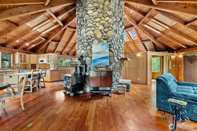 living area with wood ceiling, a skylight, and hardwood / wood-style flooring