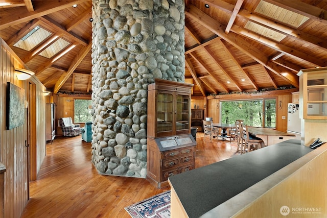 interior space with freestanding refrigerator, a skylight, wooden ceiling, and hardwood / wood-style flooring