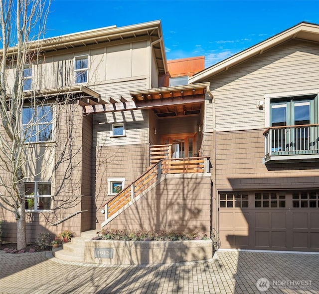 view of property with a garage and stairs