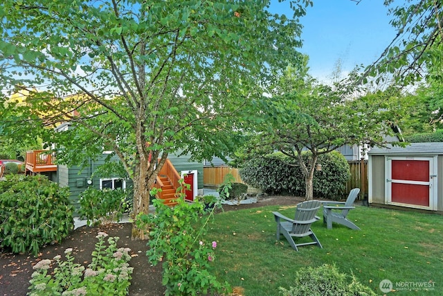 view of yard with fence, an outdoor structure, and a shed