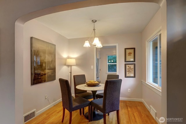 dining space featuring visible vents, light wood-style flooring, and baseboards