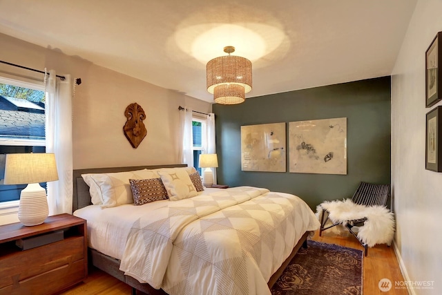 bedroom featuring baseboards and wood finished floors