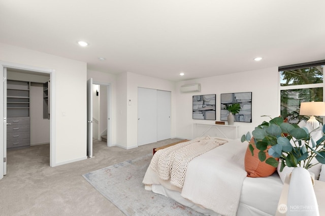 bedroom featuring a closet, recessed lighting, light colored carpet, and a wall mounted AC