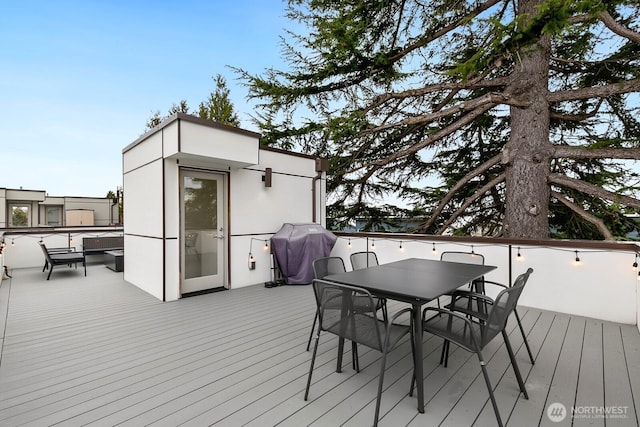 wooden deck featuring outdoor dining space and a grill