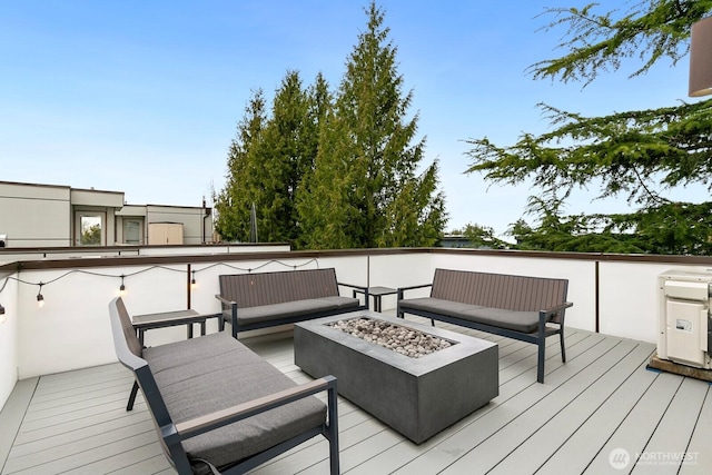 deck featuring an outdoor living space with a fire pit