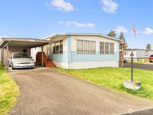 manufactured / mobile home featuring a carport, a front lawn, and driveway