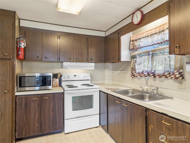 kitchen with stainless steel microwave, ventilation hood, light floors, light countertops, and electric stove