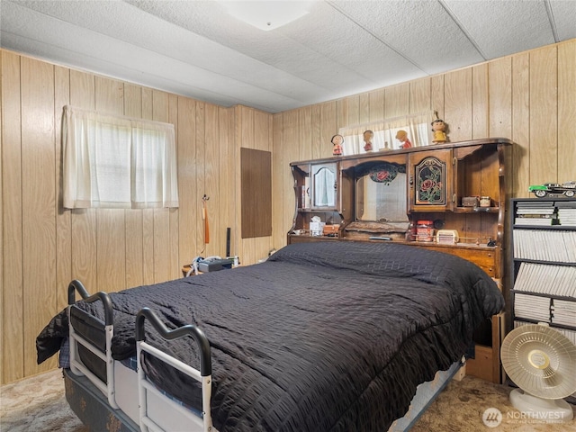 bedroom with carpet and wood walls