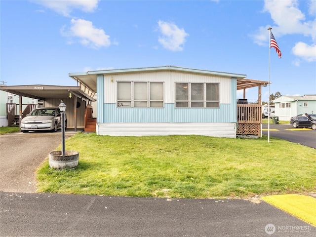 manufactured / mobile home with an attached carport, driveway, and a front lawn