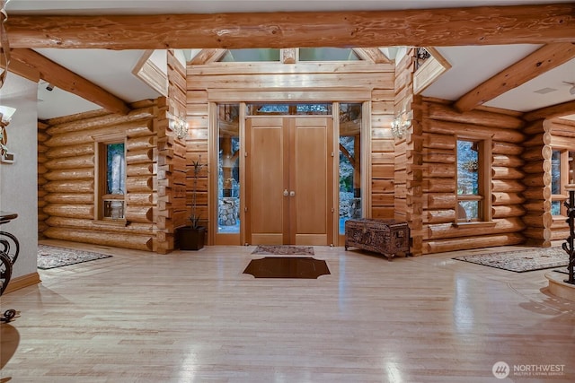 entryway featuring rustic walls, beamed ceiling, and wood finished floors